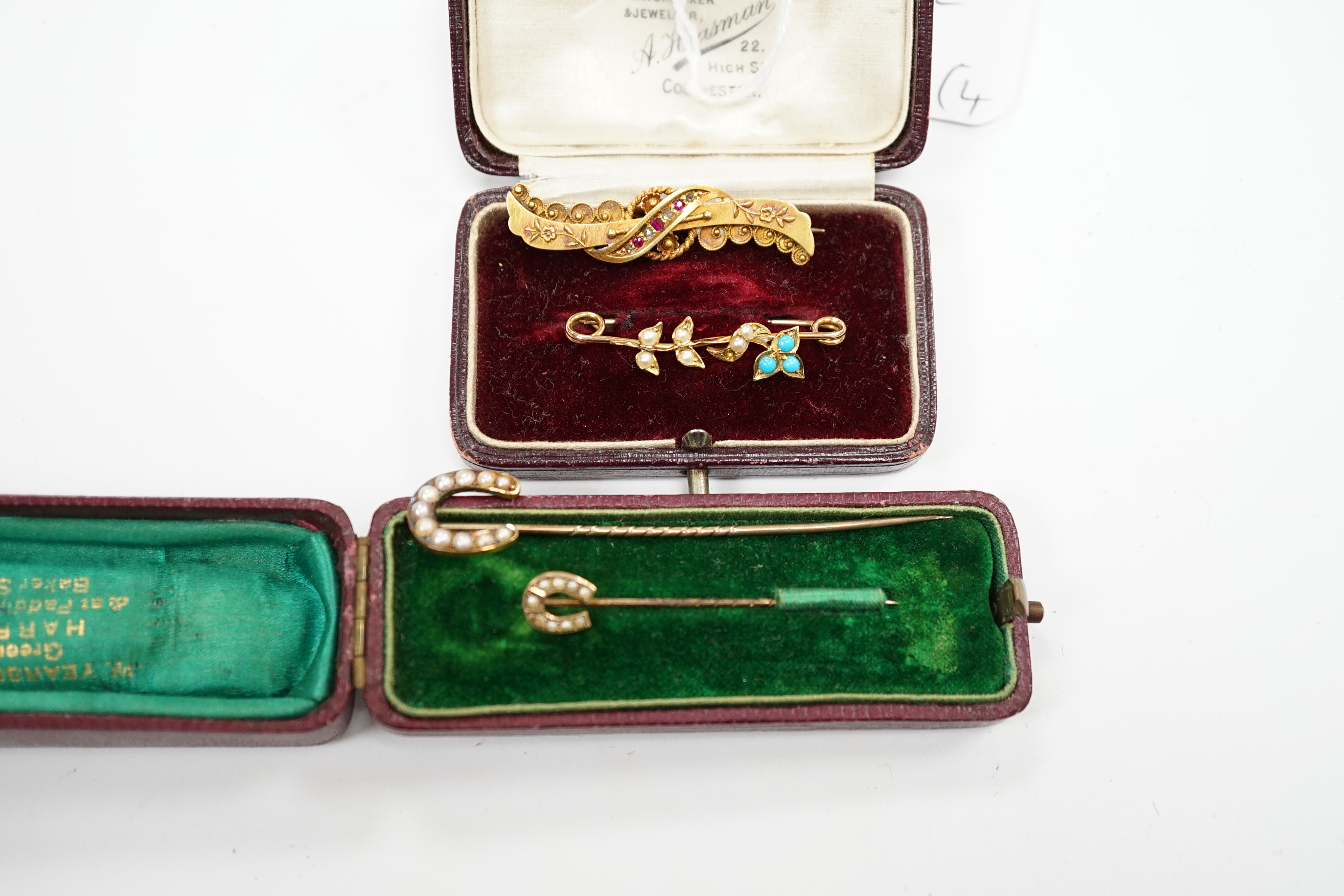 A late Victorian 15ct gold, ruby and diamond chip set bar brooch, 39mm, a yellow metal, seed pearl and turquoise set bar brooch and two seed pearl set horseshoe stick pins, one stamped 9ct, the other 18. Condition - fair